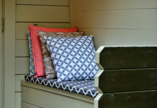 Gezellig bankje met kleurrijke kussens in Daisy Glamping Pod in het Verenigd Koninkrijk, ideaal om te ontspannen.