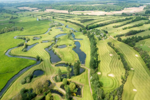 Aerial view of a scenic green golf course with winding ponds near Lilypad Bell Tent, United Kingdom.