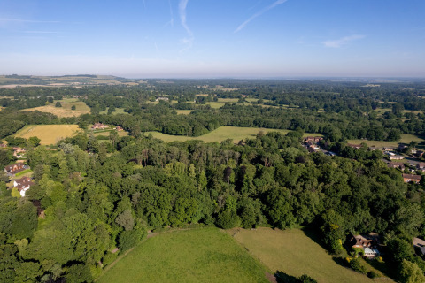 Luchtfoto van groene weilanden en bossen naast Daisy Glamping Pod, Verenigd Koninkrijk, op een zonnige dag.