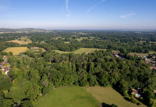 Luchtfoto van groene weilanden en bossen naast Daisy Glamping Pod, Verenigd Koninkrijk, op een zonnige dag.