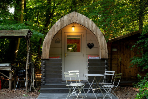 Knusse Daisy Glamping Pod met buitenterras in een bosrijke omgeving in het Verenigd Koninkrijk.