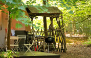 Pod de glamping confortable avec mobilier rustique près d’un barbecue à Bluebelle Glamping Pod, Royaume-Uni.