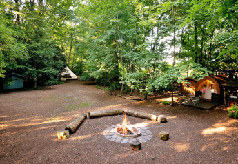 Zone de glamping en forêt avec feu de camp, tente et pod, Bluebelle Glamping Pod, Royaume-Uni.