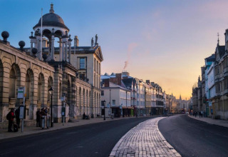 Billede af en historisk gade i Oxford, Storbritannien, ved solnedgang med gamle bygninger og rolig stemning.