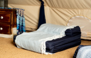 Interno della Moroccan Bell Tent nel Regno Unito con materasso pieghevole, coperta e cassettiera.
