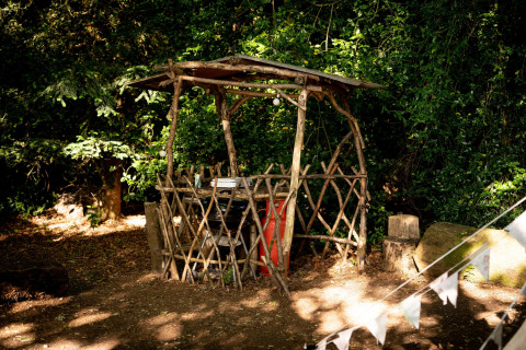 Capanno rustico di legno naturale con tetto semplice, immerso nei boschi vicino alla Moroccan Bell Tent, UK.