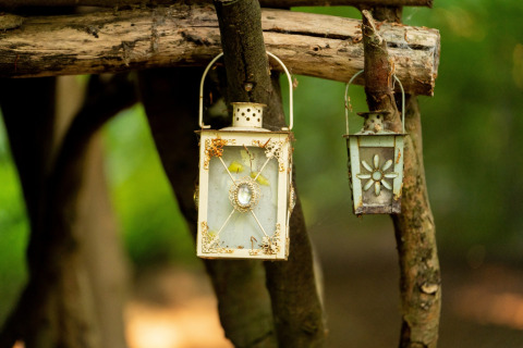 Due lanterne decorative appese ai rami vicino alla Moroccan Bell Tent nel Regno Unito.