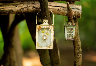 Due lanterne decorative appese ai rami vicino alla Moroccan Bell Tent nel Regno Unito.