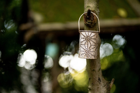 Una lanterna decorativa marocchina appesa a un albero alla Moroccan Bell Tent nel Regno Unito, sfondo sfocato.