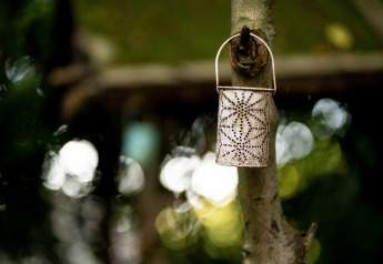Una lanterna decorativa marocchina appesa a un albero alla Moroccan Bell Tent nel Regno Unito, sfondo sfocato.