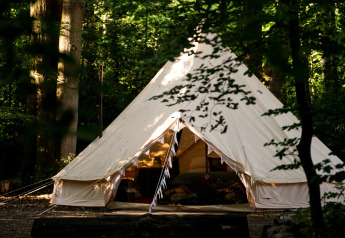 Tenda campana marocchina in una foresta del Regno Unito, vista esterna con ingresso aperto e luce diurna.