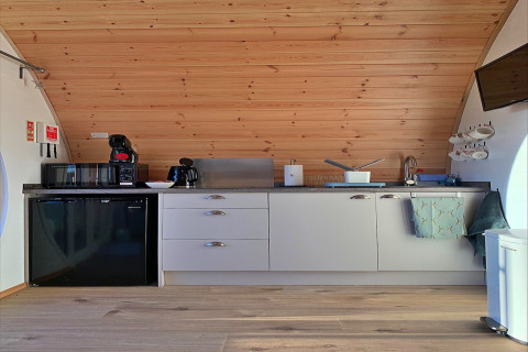 Moderne pod-keuken in Hundle Dale, Verenigd Koninkrijk, met houten plafond en compacte toestellen.