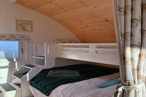 Hundle Dale pod in het Verenigd Koninkrijk met stapelbed, houten plafond en gordijnen met dierenprint.