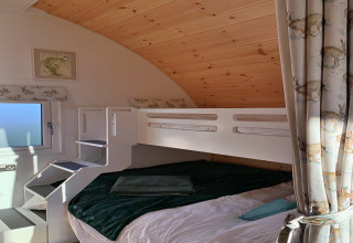 Hundle Dale pod in het Verenigd Koninkrijk met stapelbed, houten plafond en gordijnen met dierenprint.