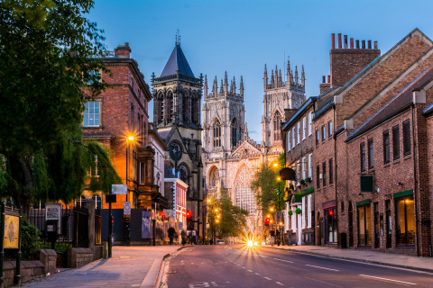 Avondzicht op een lege straat in York, Verenigd Koninkrijk, met de verlichte kathedraal en oude gebouwen.