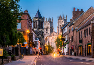 Avondzicht op een lege straat in York, Verenigd Koninkrijk, met de verlichte kathedraal en oude gebouwen.