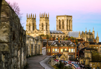 Zicht op York Minster bij valavond vanaf de stadsmuur, met historische gebouwen in York, Verenigd Koninkrijk.