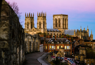 Zicht op York Minster bij valavond vanaf de stadsmuur, met historische gebouwen in York, Verenigd Koninkrijk.