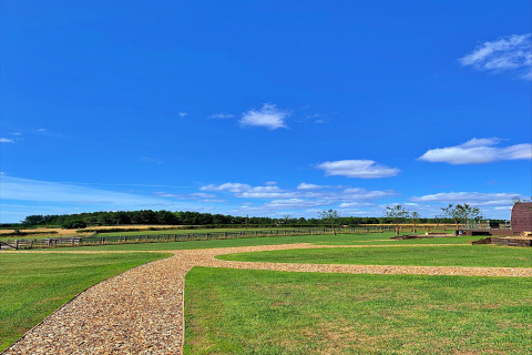 Helderblauwe lucht boven een groen veld en een grindpad aan de Hundle Dale-pod in het Verenigd Koninkrijk.
