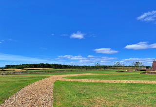 Helderblauwe lucht boven een groen veld en een grindpad aan de Hundle Dale-pod in het Verenigd Koninkrijk.