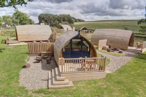 Houten glamping pods bij Blackcleugh Glamping in het Verenigd Koninkrijk, midden in het groene landschap.