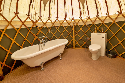 Bagno di lusso nella Bramble Yurt con vasca indipendente e WC, situato nel Regno Unito.