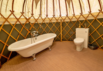 Luxe badkamer in Bramble Yurt met vrijstaand bad en toilet, gelegen in het Verenigd Koninkrijk.