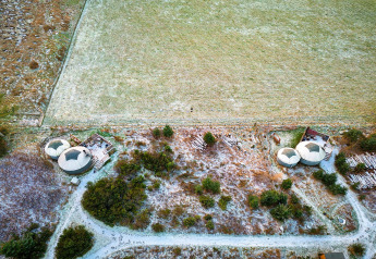 Luftaufnahme der Bramble Yurt im Vereinigten Königreich mit zwei Rundzelten in winterlicher Landschaft.