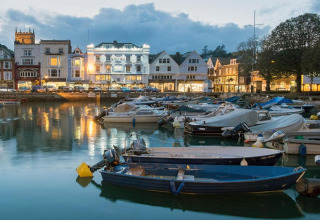 Vue du soir sur des bateaux amarrés au port et les bâtiments illuminés depuis Oak Tree Lodge au Royaume-Uni.
