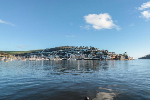 Vue sur une ville portuaire et des bateaux depuis le mobil-home Oak Tree Lodge au Royaume-Uni, ciel bleu clair.