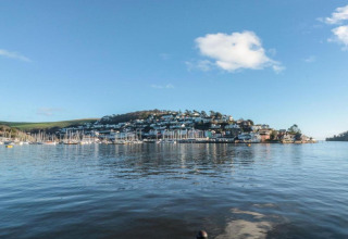 Vue sur une ville portuaire et des bateaux depuis le mobil-home Oak Tree Lodge au Royaume-Uni, ciel bleu clair.