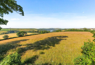 Vue panoramique sur des champs et collines verdoyants depuis le mobil-home Oak Tree Lodge au Royaume-Uni.