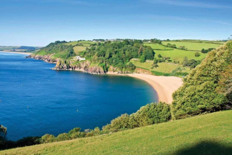 Vue depuis Oak Tree Lodge au Royaume-Uni sur une baie de sable, collines vertes et côte magnifique.
