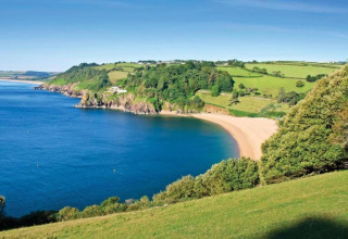 Vue depuis Oak Tree Lodge au Royaume-Uni sur une baie de sable, collines vertes et côte magnifique.