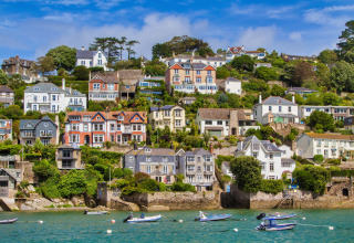 Maisons colorées sur la colline en bord de mer, avec petits bateaux, vues d'Oak Tree Lodge au Royaume-Uni.