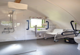 Toegankelijke badkamer in Humbleton Glamping pod, met douche, beugels en verrijdbare douchestoel.
