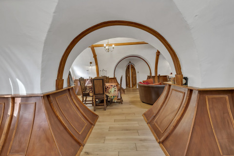 Vista interna del Pod «Hollow» nel Regno Unito con archi in legno e arredamento rustico.