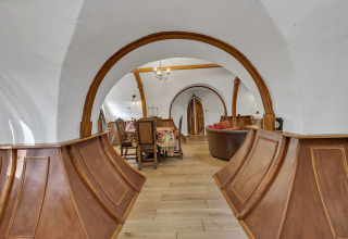 Vista interna del Pod «Hollow» nel Regno Unito con archi in legno e arredamento rustico.