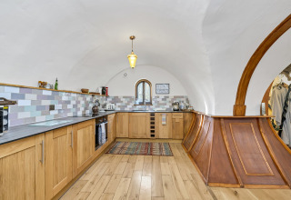 Cucina moderna nel pod 'Hollow' nel Regno Unito con soffitto a volta e piastrelle in tonalità pastello.