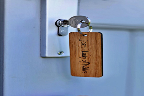 Sleutel in deur met houten label 'Joan: Lady of Wales' bij Joan Shepherds Hut mobiele woning in VK.