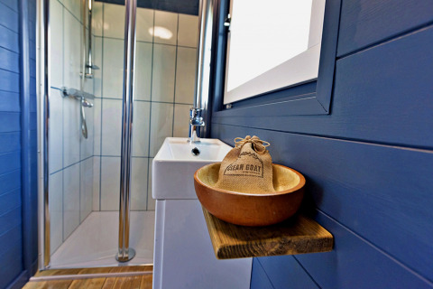 Bagno moderno nel mobil home Susanna Poachers Hut, Regno Unito, con doccia e lavabo elegante.