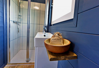 Bagno moderno nel mobil home Susanna Poachers Hut, Regno Unito, con doccia e lavabo elegante.