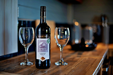 Una bottiglia di Hardys Cabernet Merlot 2020 e due calici su tavolo in legno nel mobilhome 'Susanna' Poachers Hut, Regno Unito.