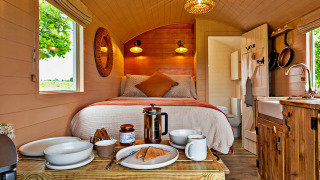 Interior of 'Marared' Gypsy Hut, featuring a cozy tiny house with bed, kitchenette, and breakfast on table.
