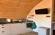 Gezellige kitchenette met tassen, handdoeken, televisie en gootsteen in de 'Worm Dale' pod in het VK.