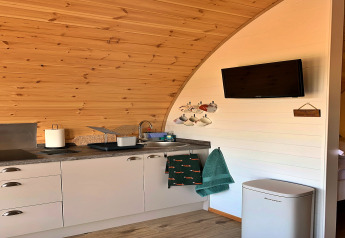 Gezellige kitchenette met tassen, handdoeken, televisie en gootsteen in de 'Worm Dale' pod in het VK.