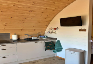 Petite cuisine moderne avec évier, tasses, serviettes et télévision dans le pod « Worm Dale » au Royaume-Uni.