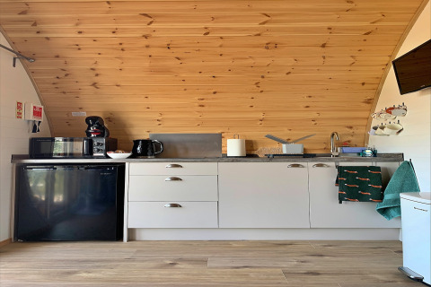 Petite cuisine moderne dans le pod Worm Dale avec murs en bois et appareils au Royaume-Uni.