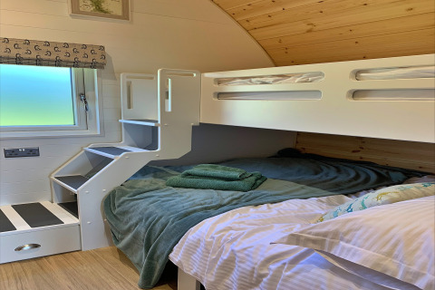 Coin nuit confortable dans la pod Worm Dale au Royaume-Uni, avec lits superposés modernes et fenêtre.