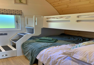 Coin nuit confortable dans la pod Worm Dale au Royaume-Uni, avec lits superposés modernes et fenêtre.